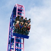 a group of people riding a roller coaster at an amusement park