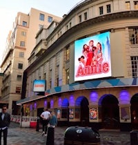 a man is walking down the street in front of a large building