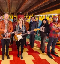 a group of people standing in a room with guitars