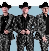 three men in cowboy suits posing in front of a blue background