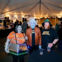 three people posing for a photo in a tent